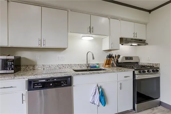 a kitchen with stainless steel appliances granite countertop a sink stove and cabinets
