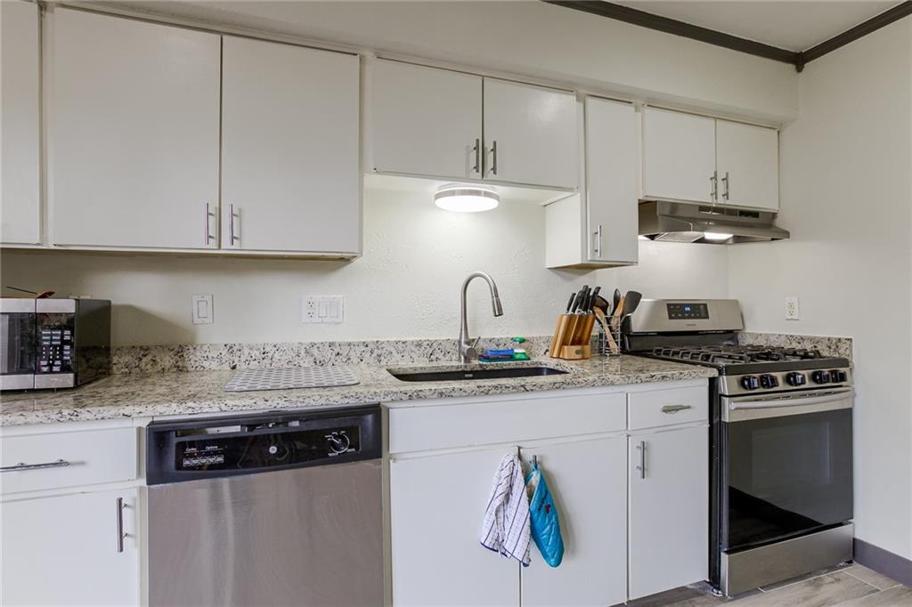 620 South 1st Street, Unit 107 Austin, TX 78704 - Photo 10 of 22 a kitchen with stainless steel appliances granite countertop a sink stove and cabinets