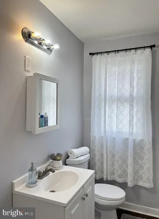 a bathroom with a toilet a sink and a mirror