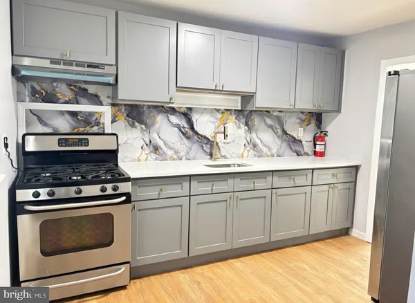 a kitchen with stainless steel appliances granite countertop a stove and white cabinets