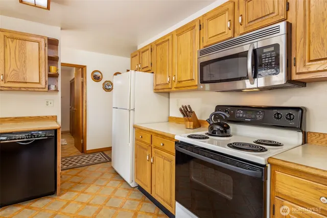 a kitchen with stainless steel appliances granite countertop a stove microwave and refrigerator