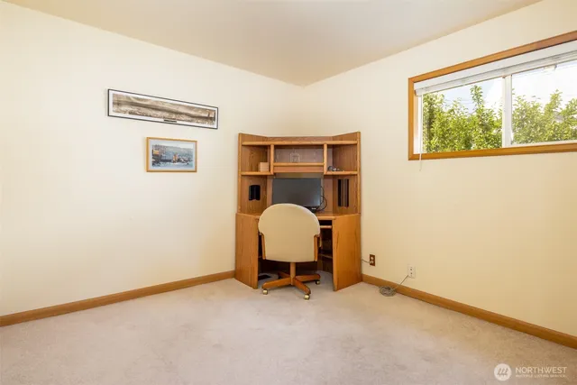 a view of a workspace with furniture and a window