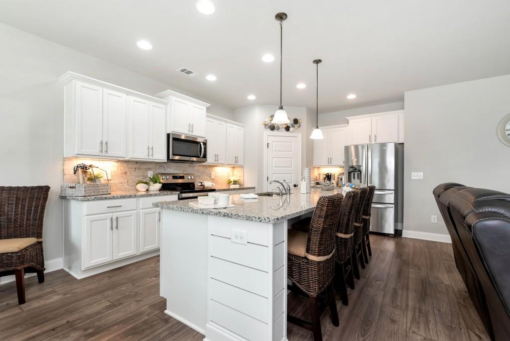 1311 Calgary Lake Drive Winder, GA 30680 - Photo 15 of 45 a kitchen with kitchen island granite countertop a sink a counter space stainless steel appliances and cabinets