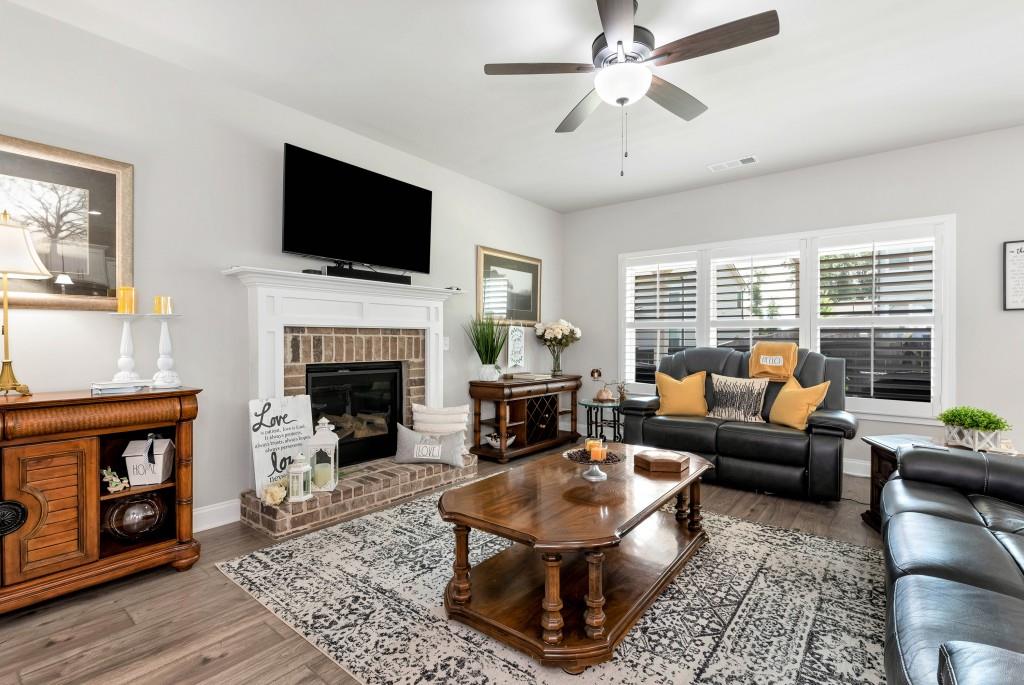 1311 Calgary Lake Drive Winder, GA 30680 - Photo 10 of 45 a living room with furniture a fireplace and a flat screen tv