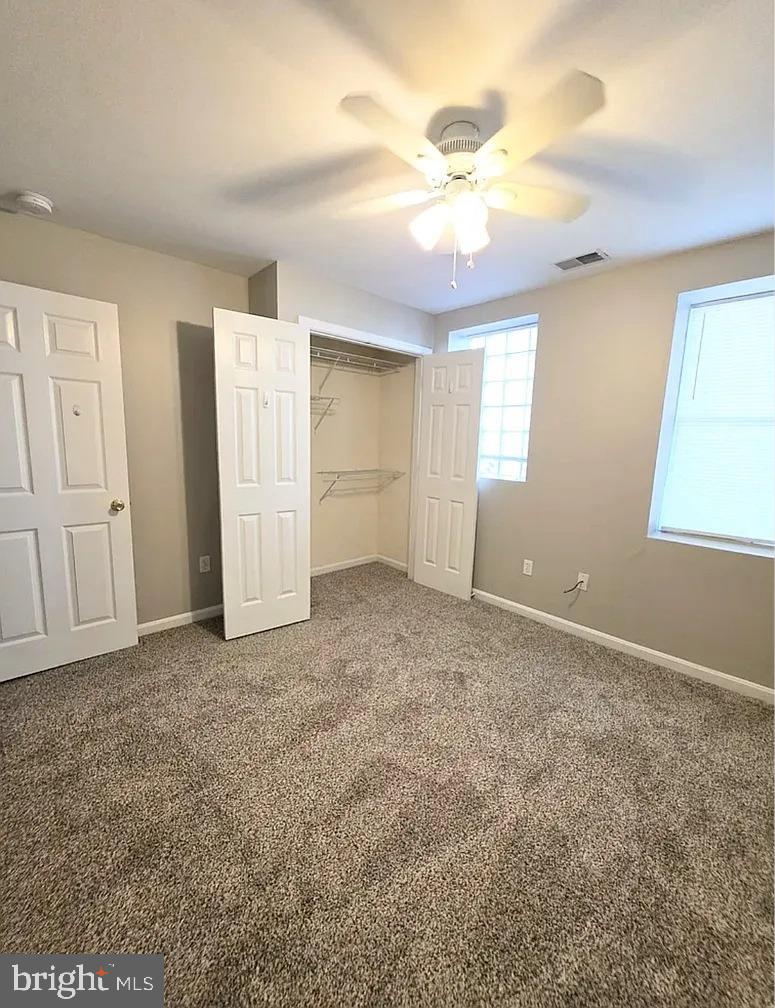 2128 Fleet Street, Unit 1 Baltimore, MD 21231 - Photo 4 of 11 an empty room with chandelier fan and windows
