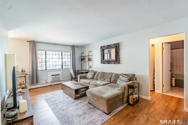 a living room with furniture and a flat screen tv with wooden floor