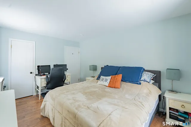 a bedroom with a bed and wooden floor