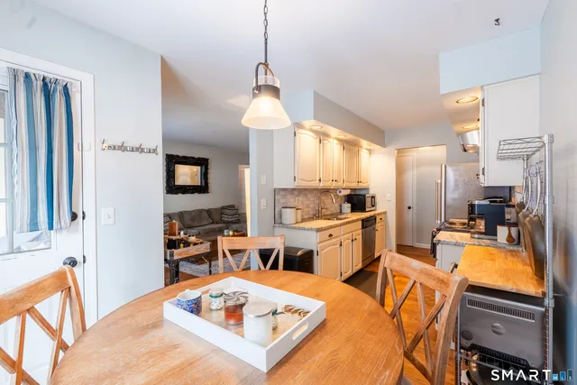 a open kitchen with stainless steel appliances kitchen island granite countertop a refrigerator a sink a stove and white cabinets