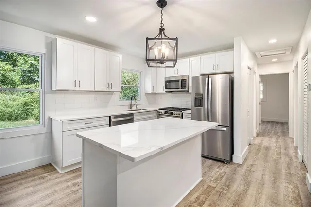 a kitchen with stainless steel appliances granite countertop a sink a refrigerator and a stove