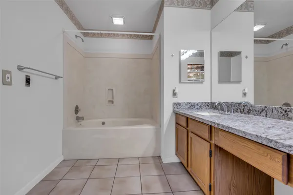 a bathroom with a granite countertop sink a toilet and shower
