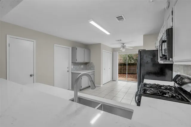 a living room with stainless steel appliances furniture a rug and a window