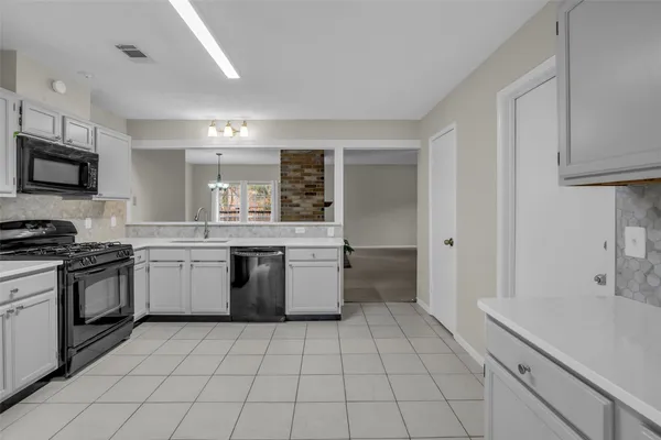 a kitchen with a sink a stove top oven and cabinets