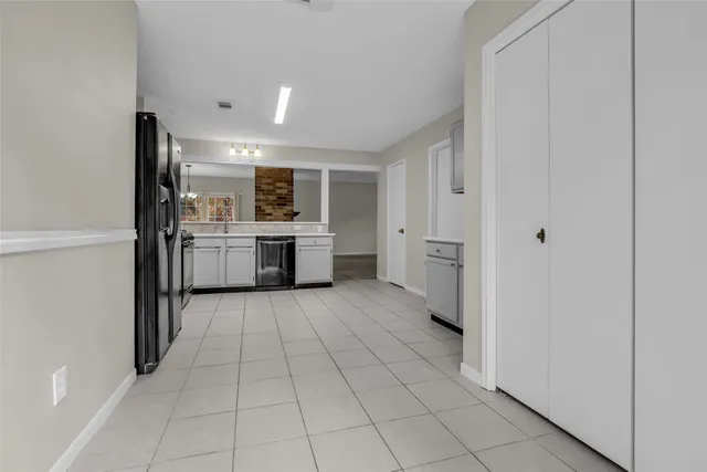 a large white kitchen with a stove a refrigerator and a sink