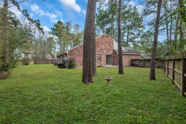 a view of a house with backyard and a tree