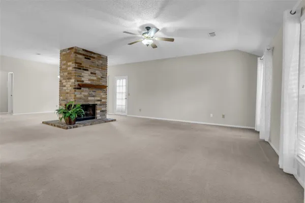an empty room with windows and ceiling fan
