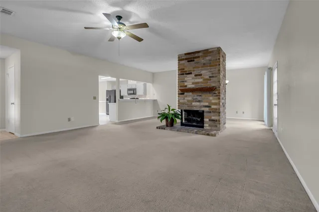 a view of a livingroom with a fireplace and a chandelier fan