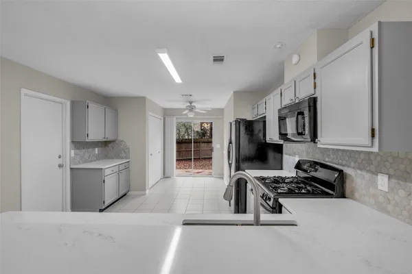 a kitchen with stainless steel appliances kitchen island granite countertop a stove and a sink