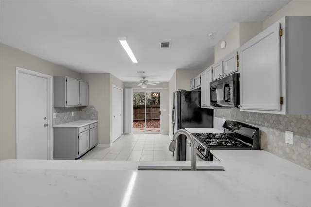 a kitchen with stainless steel appliances kitchen island granite countertop a stove and a sink