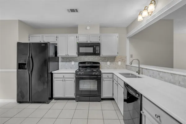 a kitchen with a sink cabinets and stainless steel appliances