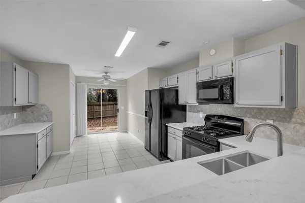 a kitchen with stainless steel appliances kitchen island granite countertop a stove sink and refrigerator