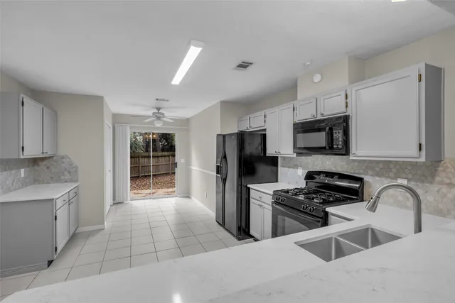 a kitchen with stainless steel appliances kitchen island granite countertop a stove sink and refrigerator