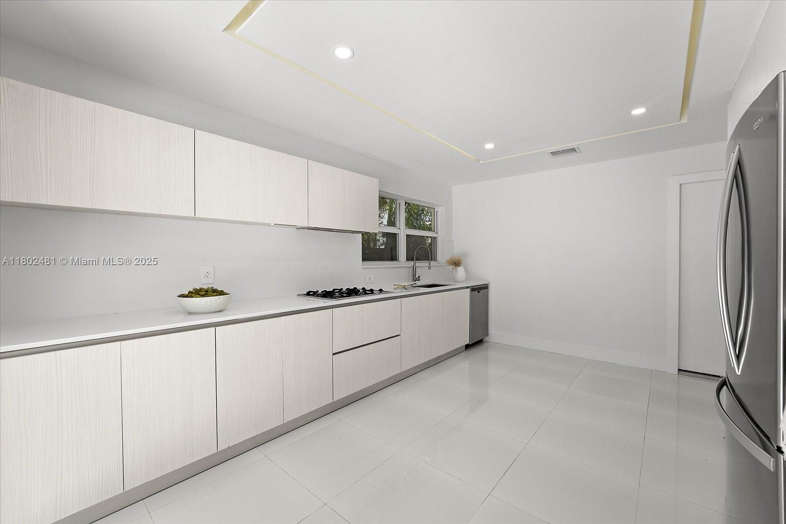 3020 Alton Road Miami Beach, FL 33140 - Photo 15 of 40 a large white kitchen with stainless steel appliances