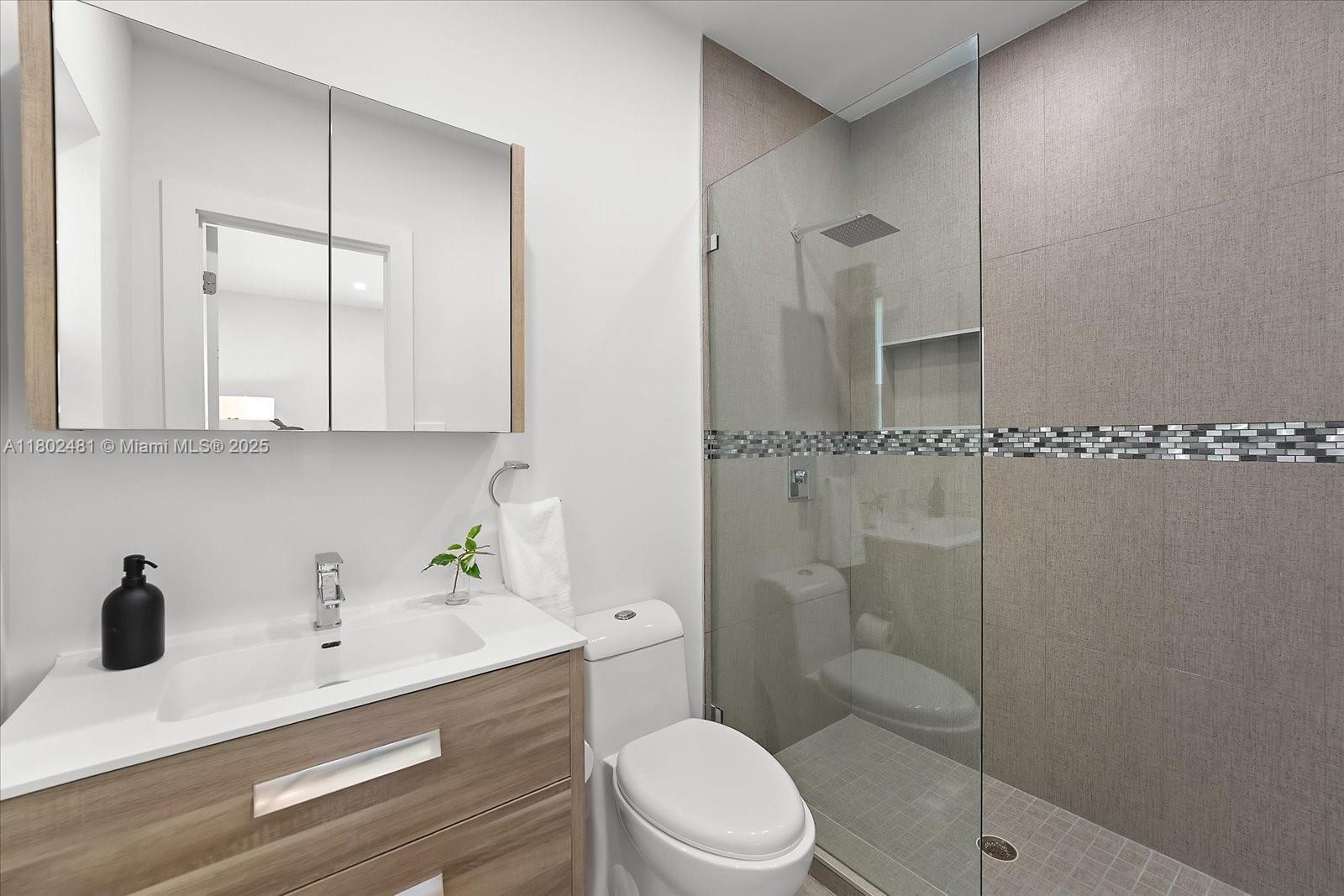 3020 Alton Road Miami Beach, FL 33140 - Photo 23 of 40 a bathroom with a sink a toilet and shower