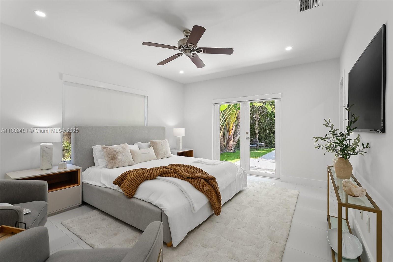 3020 Alton Road Miami Beach, FL 33140 - Photo 24 of 40 a bed room with a bed television and a large window