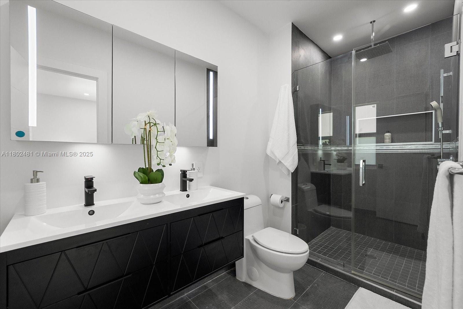 3020 Alton Road Miami Beach, FL 33140 - Photo 26 of 40 a bathroom with a sink a toilet and shower