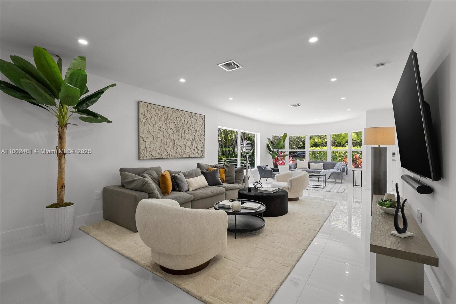 3020 Alton Road Miami Beach, FL 33140 - Photo 3 of 40 a living room with furniture a flat screen tv and a potted plant