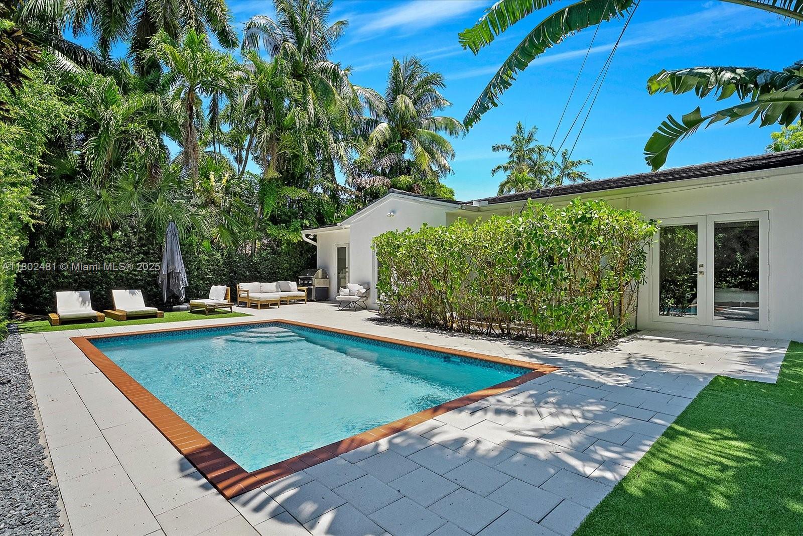 3020 Alton Road Miami Beach, FL 33140 - Photo 33 of 40 a view of a swimming pool with lounge chair