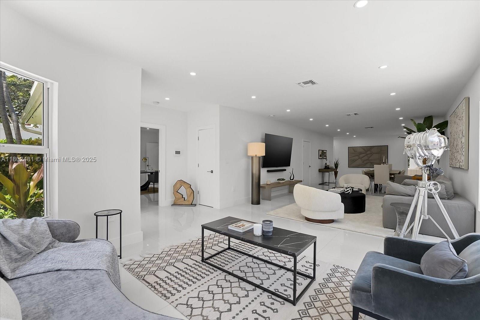 3020 Alton Road Miami Beach, FL 33140 - Photo 5 of 40 a living room with furniture and a chandelier