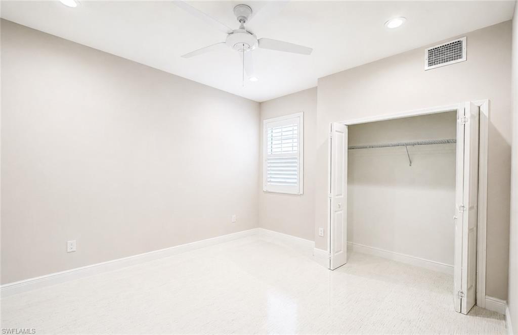 2620 Seychelles Circle, Unit 1302 Naples, FL 34112 - Photo 23 of 43 an empty room with windows and fan