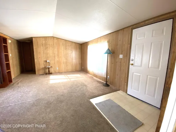 a view of an empty room with a fireplace and a window