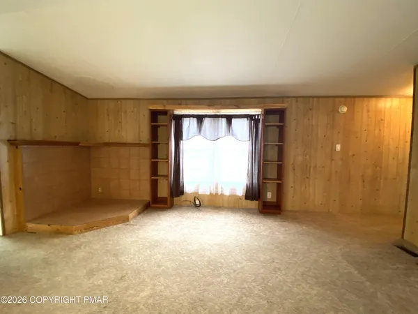 a view of a bedroom with a bed and a window