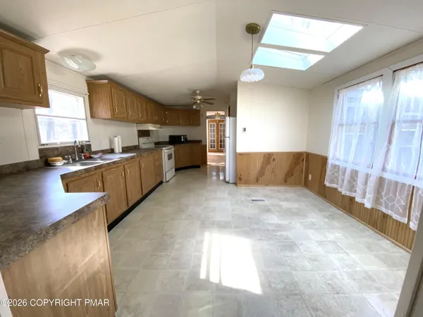 a kitchen with granite countertop a sink cabinets stainless steel appliances and a window