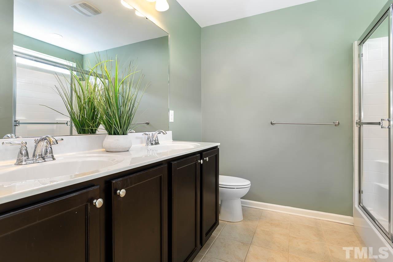 421 Provincial Street Raleigh, NC 27603 - Photo 11 of 22 a bathroom with a granite countertop sink a toilet and a mirror