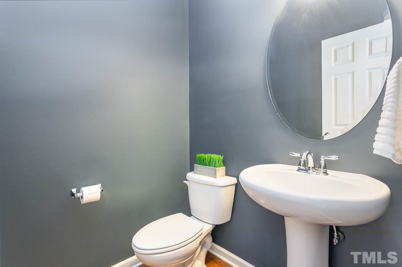 421 Provincial Street Raleigh, NC 27603 - Photo 8 of 22 a bathroom with a sink a toilet and a mirror