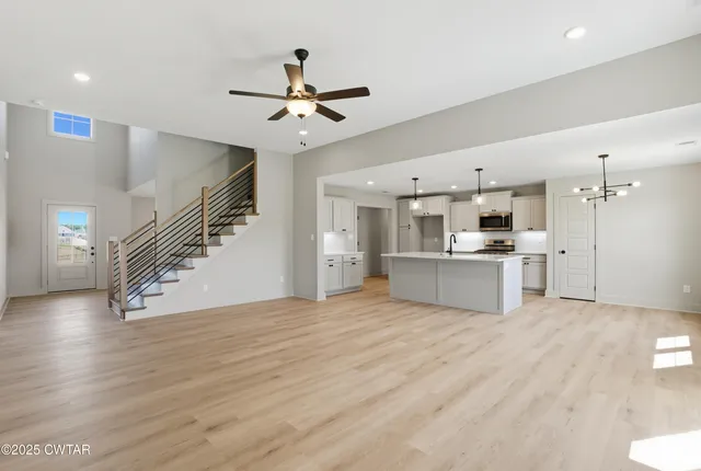 an empty room with window and ceiling fan