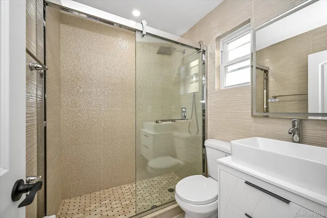 a bathroom with a sink a toilet and shower