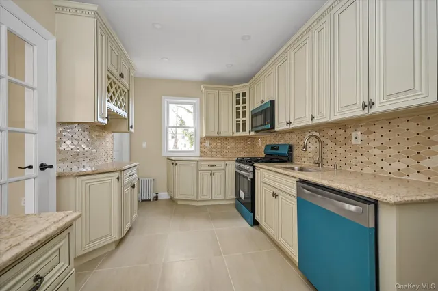 a kitchen with granite countertop a sink stainless steel appliances and cabinets