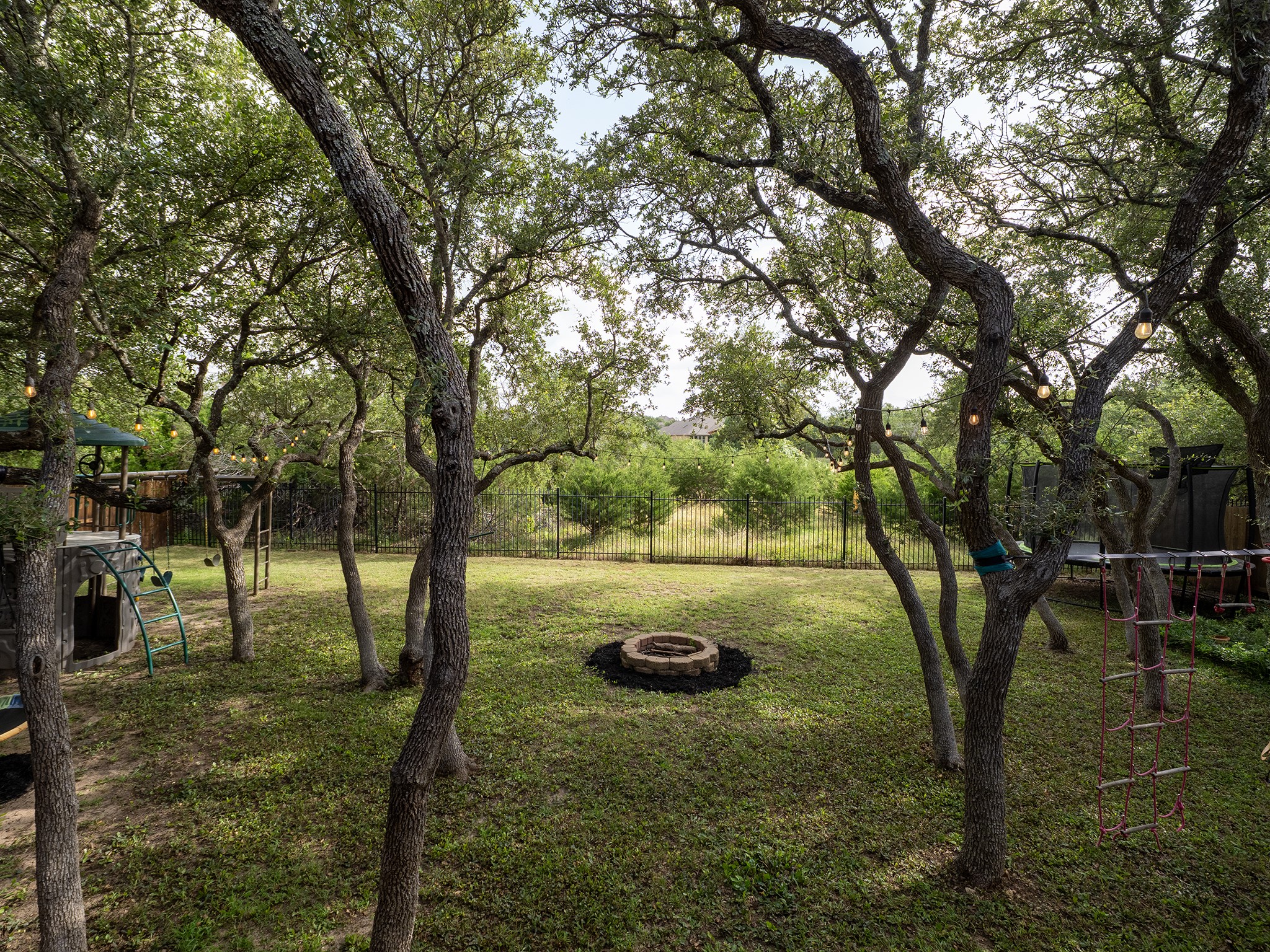572 Big Meadow Road Austin, TX 78737 - Photo 30 of 32 Mature trees and a fire pit enhance this spacious, private backyard.
