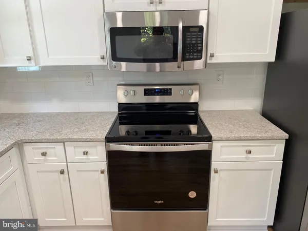 a stove top oven sitting inside of a kitchen