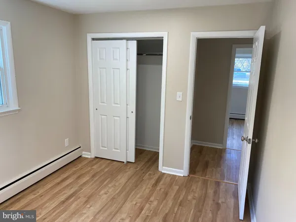 an empty room with wooden floor and closet
