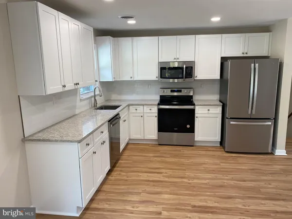 a kitchen with stainless steel appliances granite countertop a refrigerator sink and cabinets
