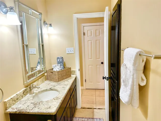 a bathroom with a granite countertop shower and a sink