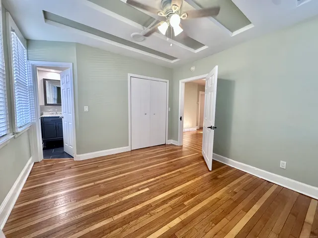 a view of a room with wooden floor and ceiling fan