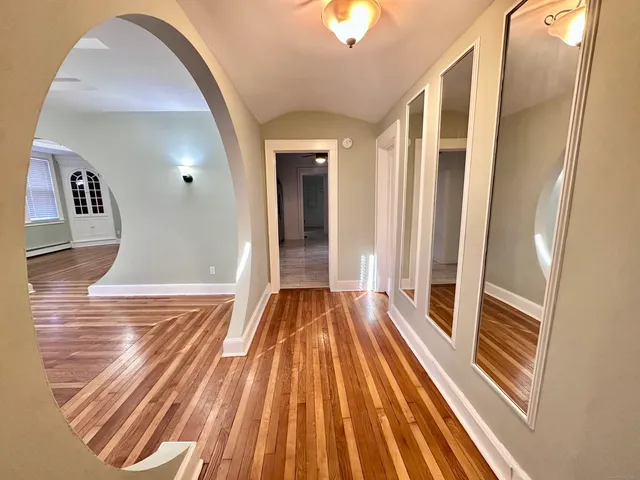 a view of a hallway view with wooden floor and staircase