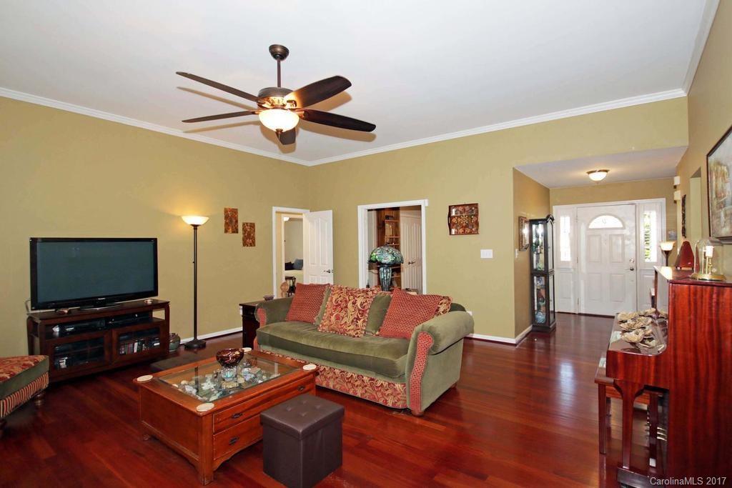 153 Kilborne Road Mooresville, NC 28117 - Photo 4 of 24 a living room with furniture a flat screen tv and a dining table