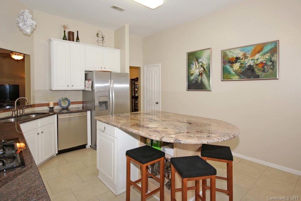153 Kilborne Road Mooresville, NC 28117 - Photo 9 of 24 a kitchen with a table chairs refrigerator and wooden floor